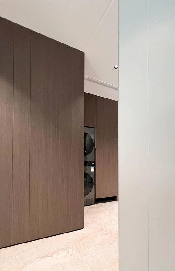 Installed wood-toned interior door beside matching vertical wall panels
