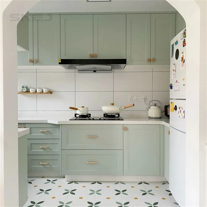 Pale green framed kitchen cabinets beneath an arched opening - Shaker Custom Cabinets by SNEJ