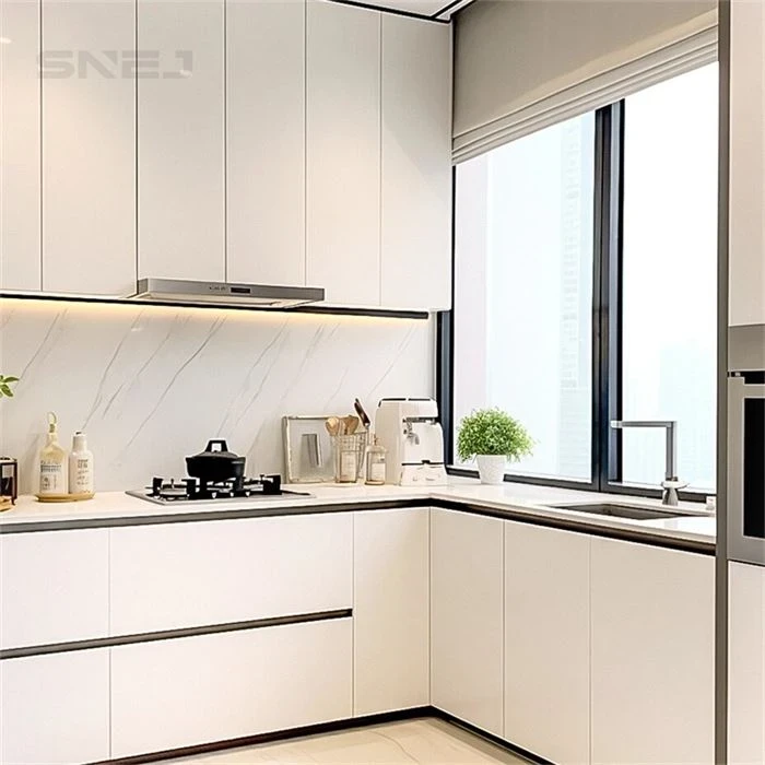 White L-shaped kitchen cabinets with a sink beneath the window - Custom Inset Kitchen Cabinets by SNEJ