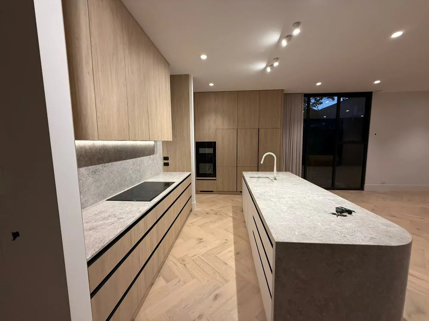 Oak kitchen cabinetry with an island and pale worktops