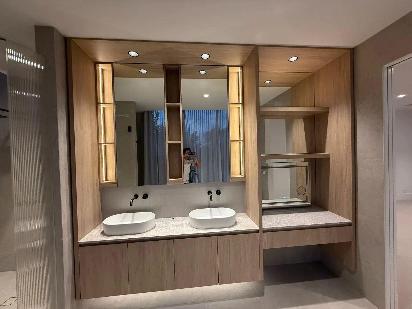Fitted vanity cabinetry with two basins and illuminated mirrors