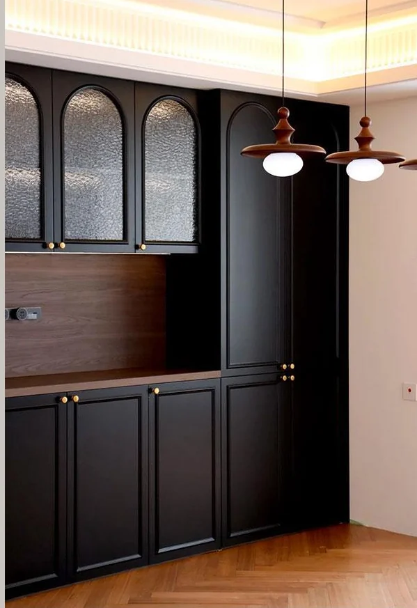 Arched glazed display cupboards above dark drawers and base cabinets