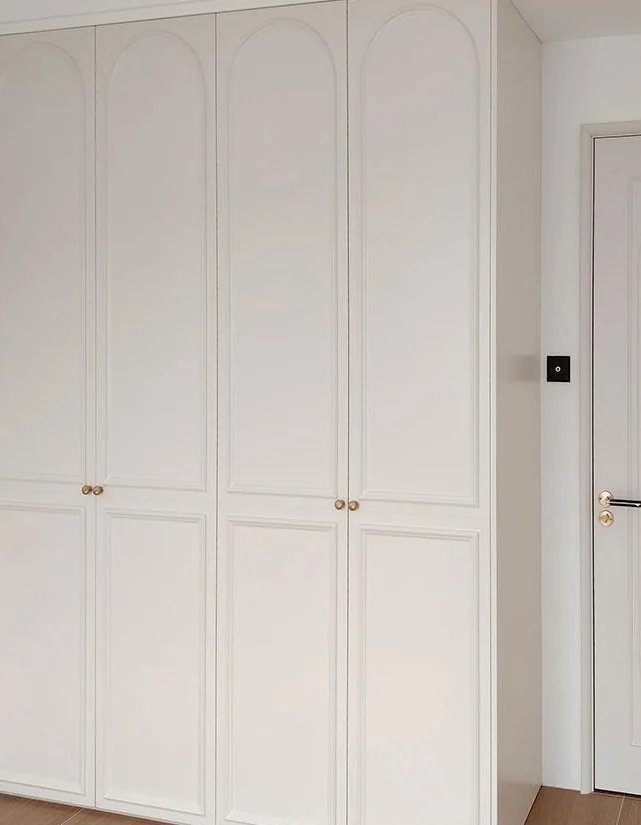 Pale framed cabinet doors with small brass-toned knobs