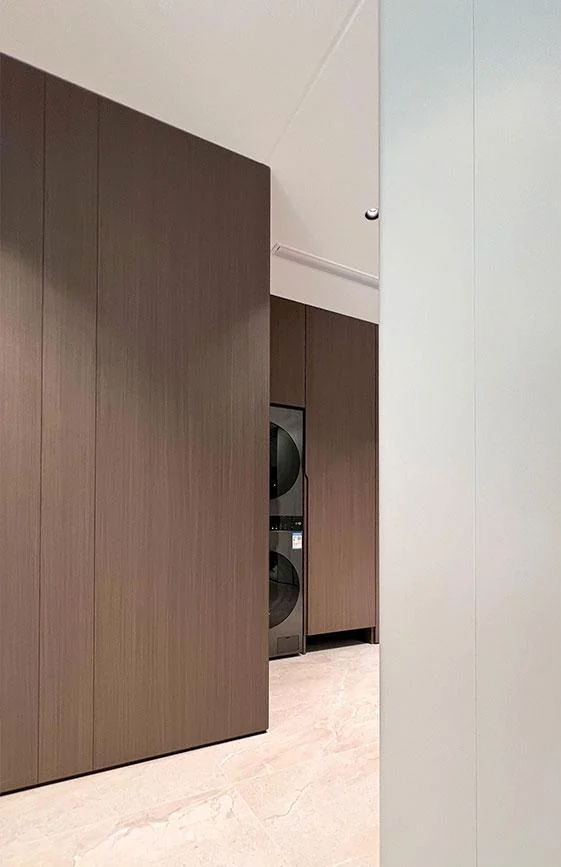 Wood-toned interior door integrated with adjacent vertical wall panels