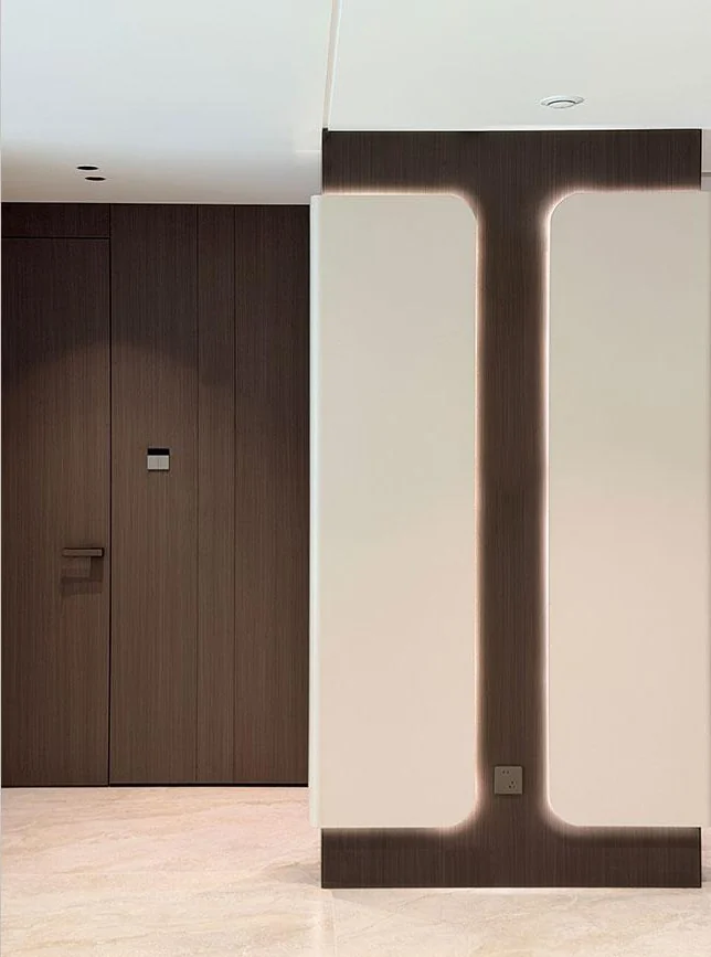 Wood-toned door and illuminated vertical wall detail beside pale panels