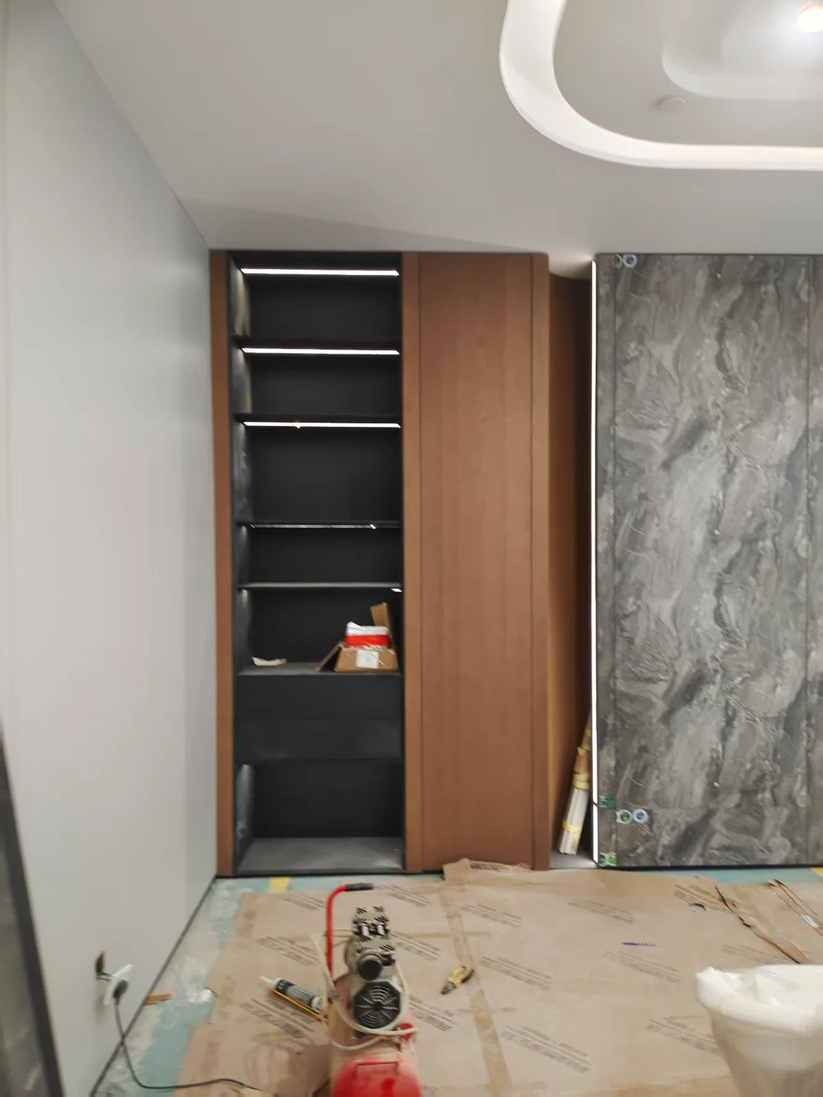 Tall storage beside a feature wall at the installation stage